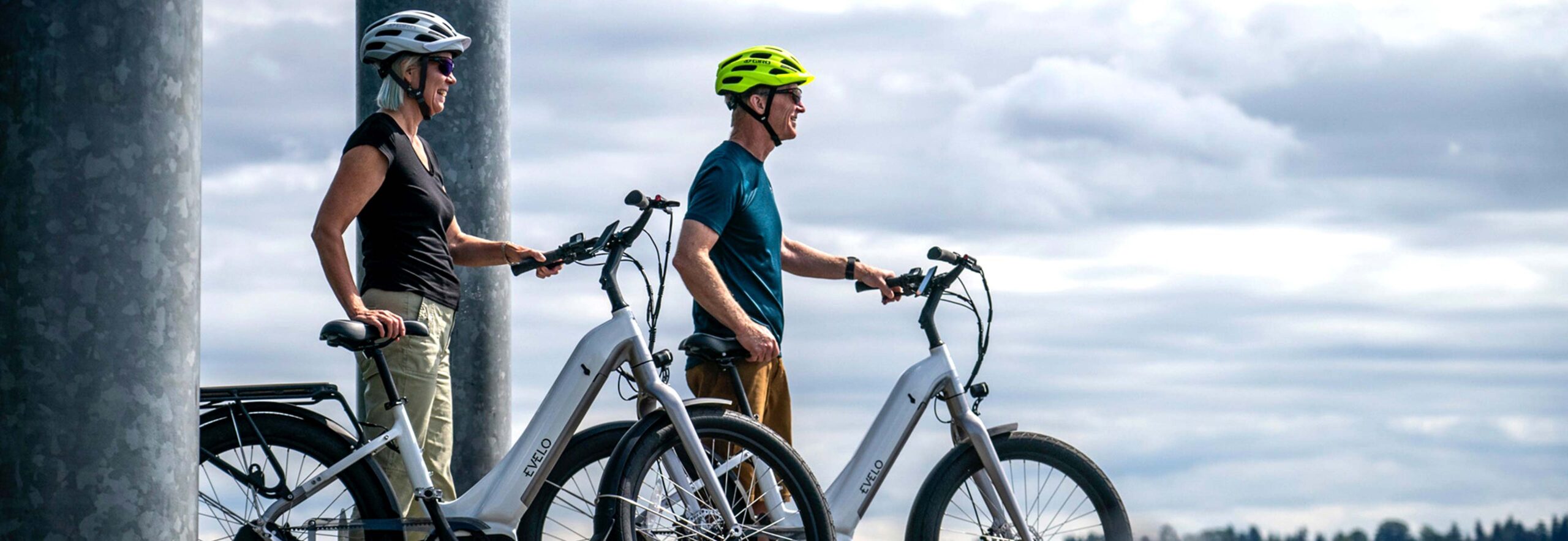 Two People Standing with Electric Bikes Two People Standing with Electric Bikes